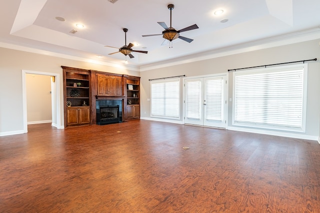 unfurnished living room with dark wood-type flooring, a fireplace, and a raised ceiling