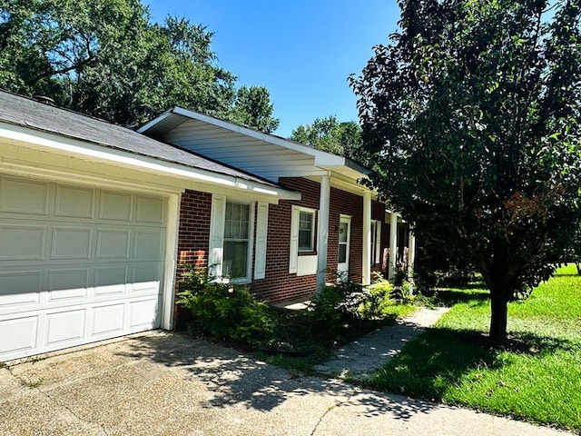 view of front of house featuring a garage, concrete driveway, and brick siding