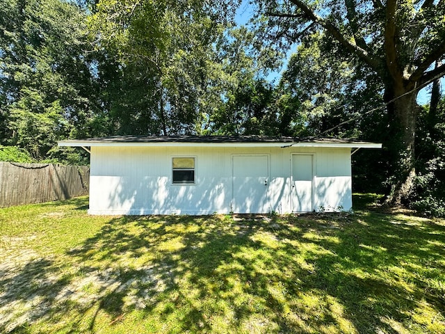 view of side of home featuring fence and a lawn