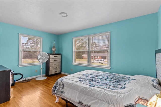 bedroom with baseboards and wood finished floors