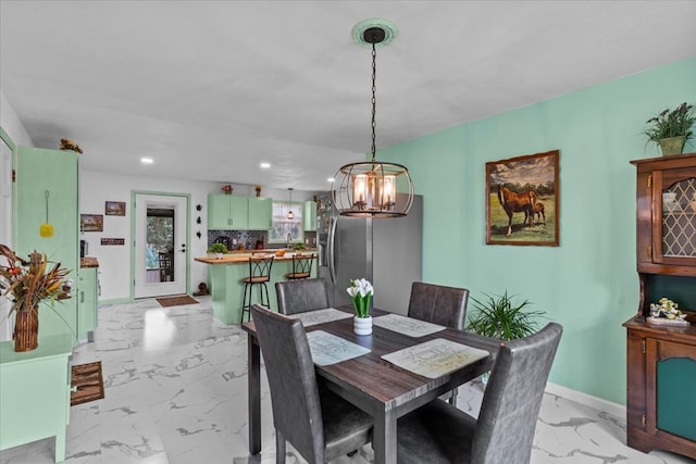 dining space featuring marble finish floor, recessed lighting, an inviting chandelier, and baseboards