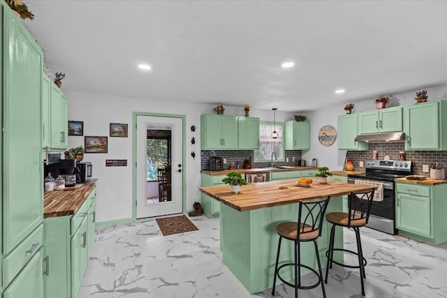 kitchen featuring marble finish floor, electric stove, butcher block countertops, and under cabinet range hood