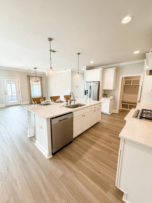 668 Charleston Mills Dr, Dothan, AL 36350 - kitchen featuring stainless steel appliances, crown molding, light wood finished floors, an island with sink, and white cabinetry