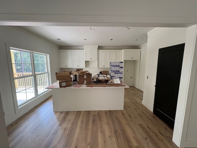 317 Old Village Rd, Ozark, AL 36360 - kitchen featuring white cabinets, light wood finished floors, ornamental molding, and a center island