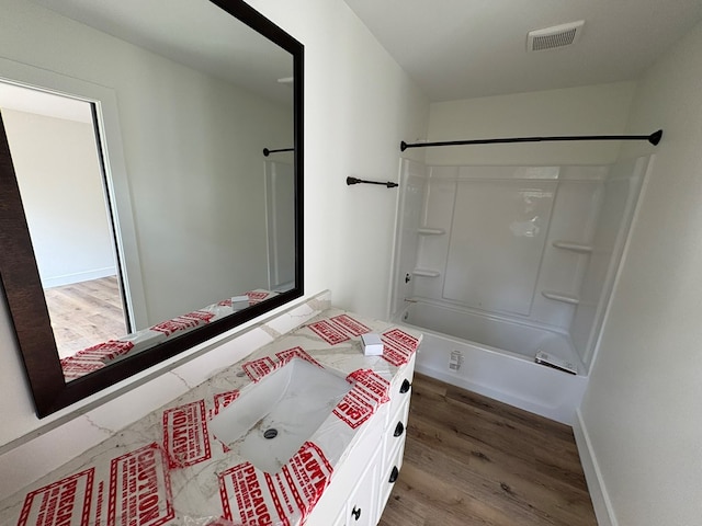317 Old Village Rd, Ozark, AL 36360 - full bath with wood finished floors, vanity, and shower / tub combination