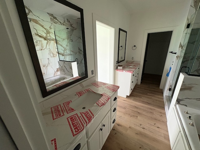 317 Old Village Rd, Ozark, AL 36360 - bathroom with vanity, a marble finish shower, a bathtub, and wood finished floors