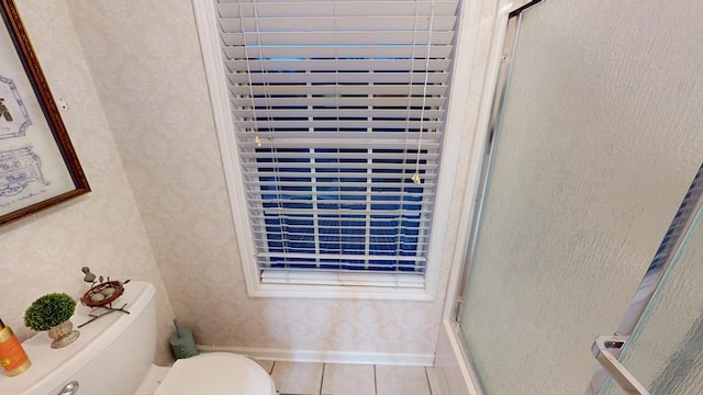 full bathroom featuring a shower with door, toilet, tile patterned floors, and wallpapered walls