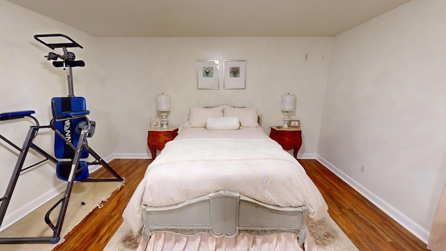 bedroom with baseboards and wood finished floors