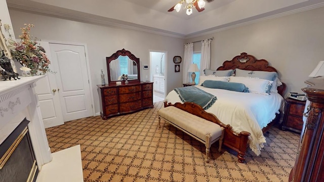 bedroom featuring ceiling fan, a tray ceiling, a fireplace, and ornamental molding