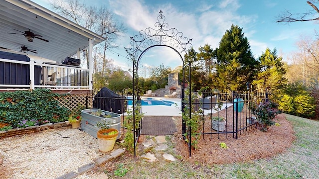 exterior space featuring a patio, fence, a garden, a fenced in pool, and ceiling fan