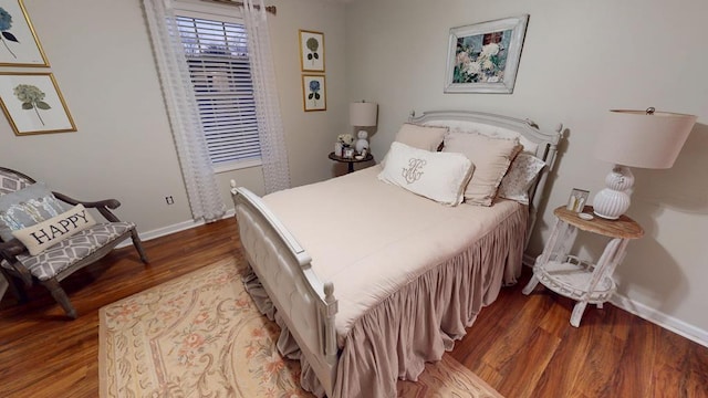 bedroom with baseboards and wood finished floors