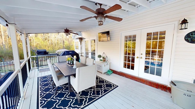 wooden terrace featuring french doors, grilling area, a ceiling fan, and outdoor dining space