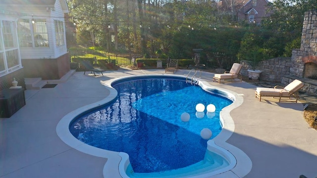 pool featuring fence and a patio area