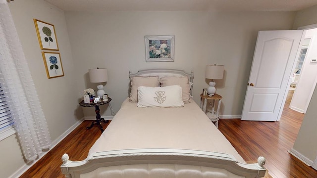 bedroom with baseboards and wood finished floors