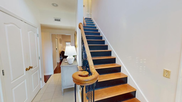 stairs featuring tile patterned floors, visible vents, and baseboards