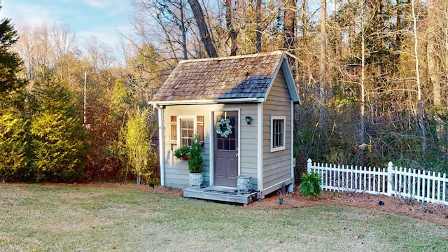 view of outdoor structure featuring an outbuilding and fence