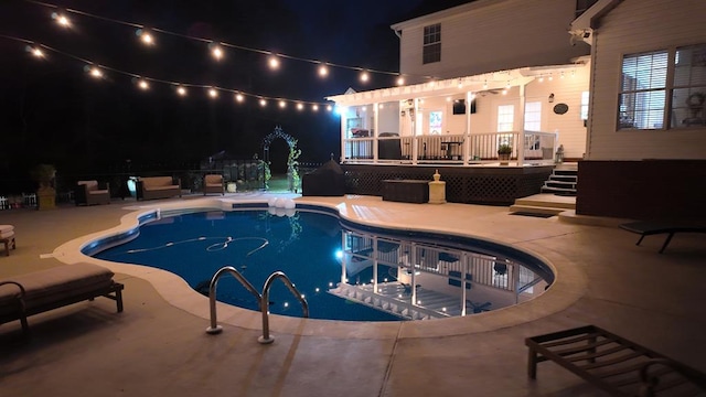 pool at twilight featuring an outdoor pool, a patio, and a deck