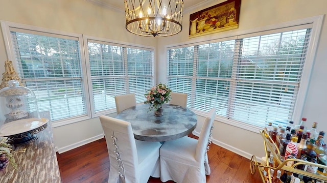 dining area with crown molding, hardwood / wood-style flooring, baseboards, and a wealth of natural light