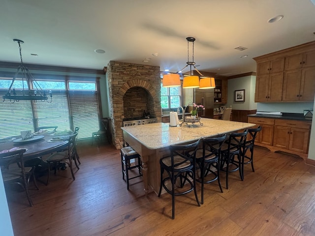 2837 Woodham Rd, Dothan, AL 36303 - kitchen featuring wood-type flooring, an island with sink, stainless steel built in refrigerator, a breakfast bar area, and crown molding