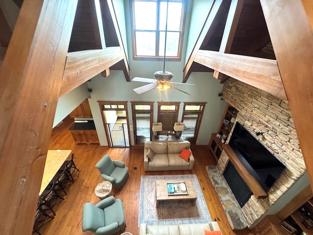2837 Woodham Rd, Dothan, AL 36303 - living area featuring a stone fireplace, ceiling fan, wood finished floors, beamed ceiling, and high vaulted ceiling