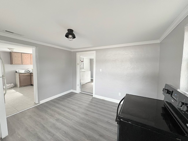 misc room featuring washer / dryer, crown molding, and light hardwood / wood-style flooring