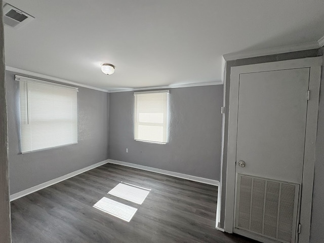 empty room featuring dark hardwood / wood-style flooring and ornamental molding