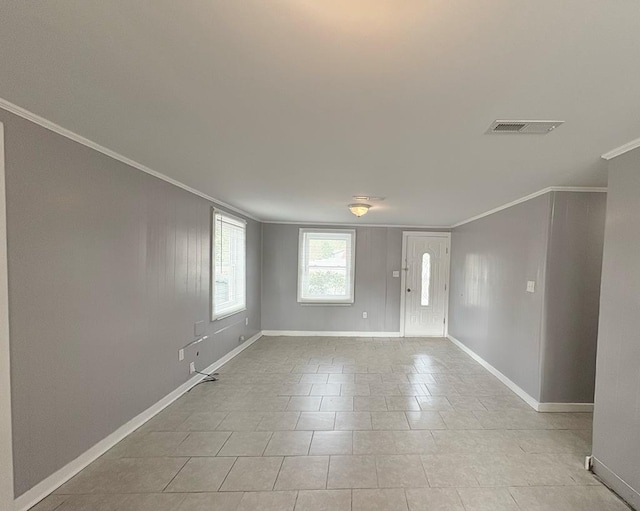 tiled spare room featuring crown molding