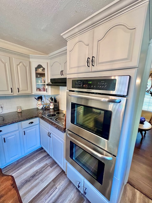 1503 Buena Vista Dr, Dothan, AL 36303 - kitchen featuring light wood-type flooring, a textured ceiling, stainless steel double oven, black electric cooktop, and backsplash