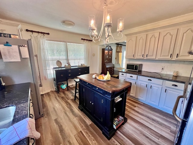 1503 Buena Vista Dr, Dothan, AL 36303 - kitchen with stainless steel microwave, wooden counters, a chandelier, light wood-type flooring, and white cabinets