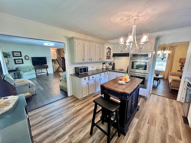 1503 Buena Vista Dr, Dothan, AL 36303 - kitchen with appliances with stainless steel finishes, a chandelier, ornamental molding, butcher block counters, and light wood-style floors