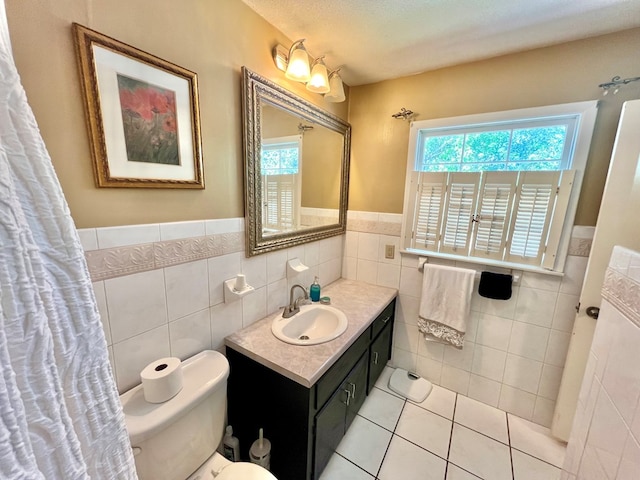 1503 Buena Vista Dr, Dothan, AL 36303 - bathroom with tile walls, tile patterned floors, toilet, vanity, and a wainscoted wall