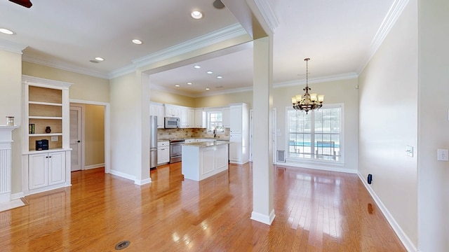 107 Boulder Dr, Dothan, AL 36305 - kitchen with stainless steel appliances, light wood-type flooring, white cabinetry, a kitchen island, and a chandelier