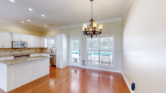 107 Boulder Dr, Dothan, AL 36305 - kitchen featuring appliances with stainless steel finishes, a sink, a chandelier, white cabinets, and ornamental molding