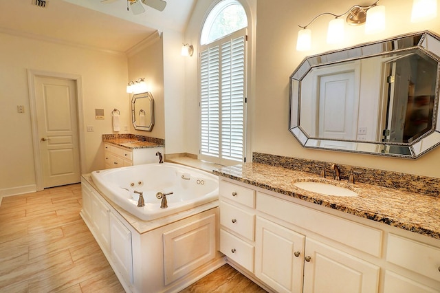 221 Asphodel Dr, Dothan, AL 36303 - bathroom with a jetted tub, two vanities, a ceiling fan, and wood finished floors