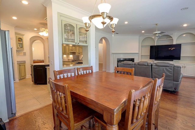 221 Asphodel Dr, Dothan, AL 36303 - dining space with arched walkways, a ceiling fan, crown molding, recessed lighting, and a glass covered fireplace