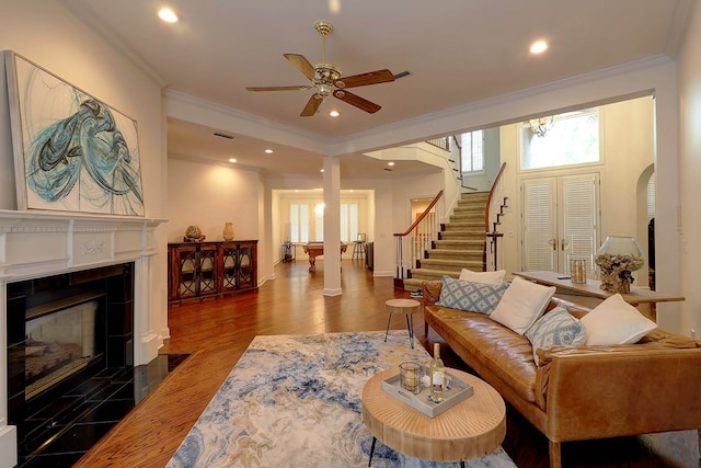 221 Asphodel Dr, Dothan, AL 36303 - living room featuring crown molding, a ceiling fan, a tile fireplace, wood finished floors, and arched walkways