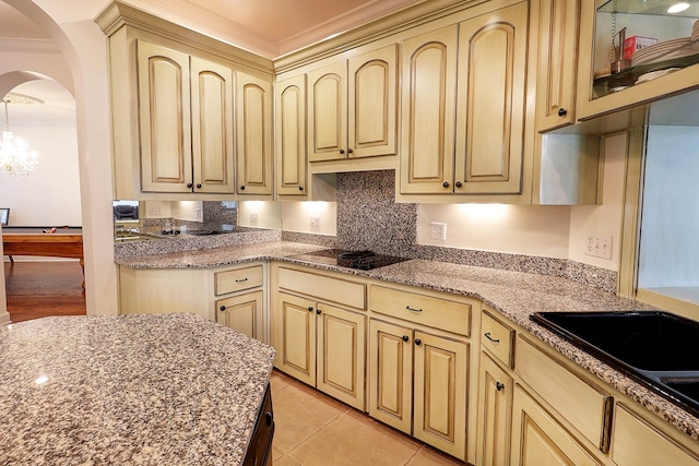 221 Asphodel Dr, Dothan, AL 36303 - kitchen featuring black electric stovetop, arched walkways, ornamental molding, cream cabinets, and a chandelier