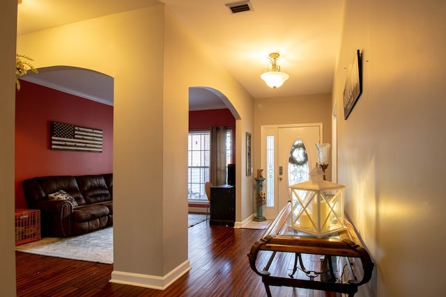 foyer with dark hardwood / wood-style floors and crown molding