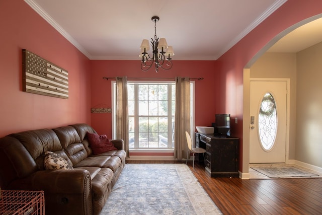 living room featuring hardwood / wood-style flooring, crown molding, and a chandelier