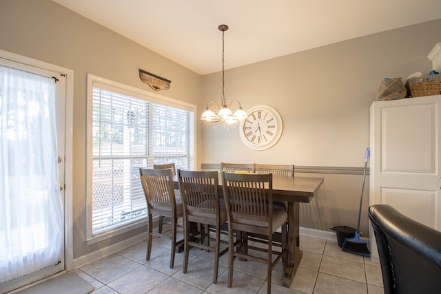 tiled dining space featuring a wealth of natural light and a notable chandelier