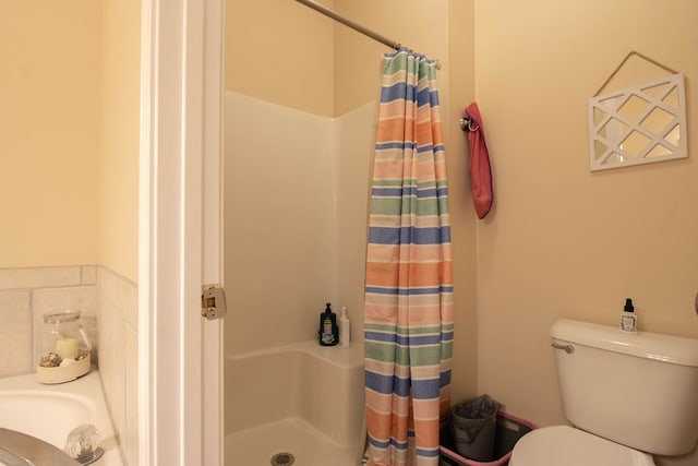 bathroom featuring curtained shower and toilet