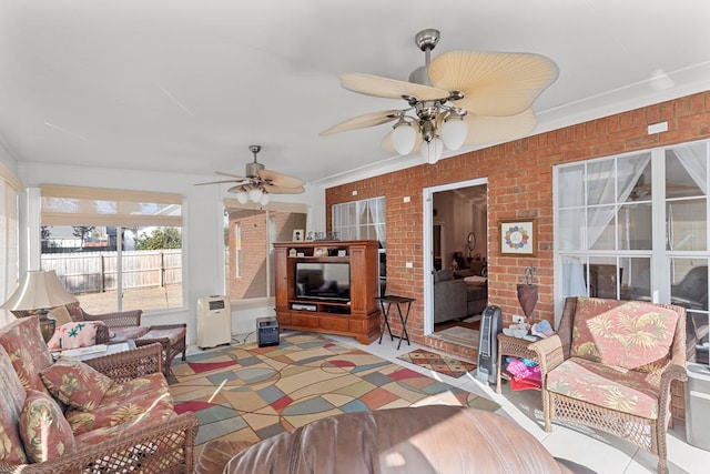 living room with ceiling fan, brick wall, and ornamental molding