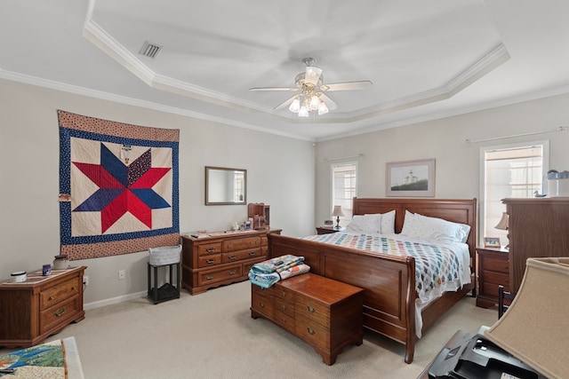 carpeted bedroom featuring ceiling fan, a tray ceiling, and ornamental molding