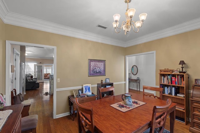 dining area with crown molding, an inviting chandelier, and dark hardwood / wood-style floors