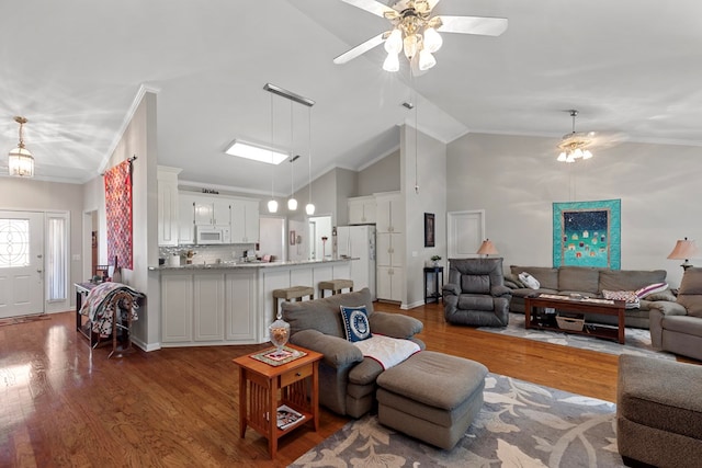 living room with hardwood / wood-style flooring, high vaulted ceiling, ceiling fan, and ornamental molding