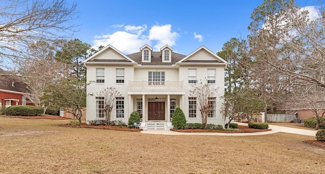 view of front facade featuring a balcony and a front lawn