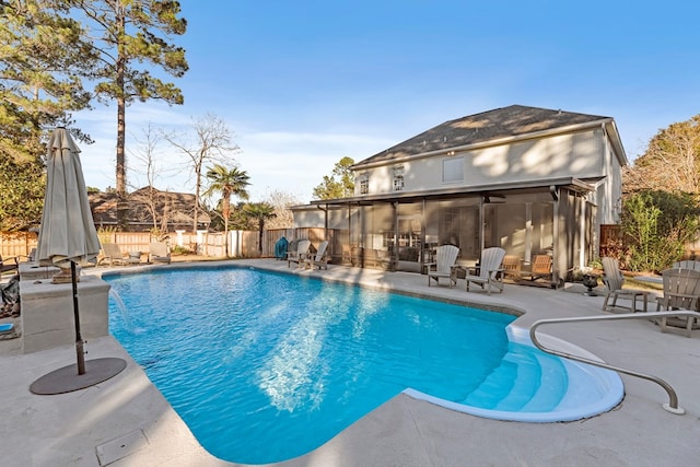 view of swimming pool with a sunroom, a patio area, and pool water feature