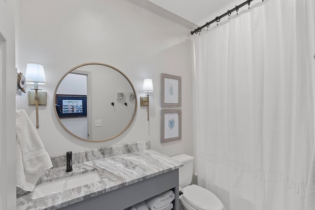 bathroom with crown molding, vanity, and toilet