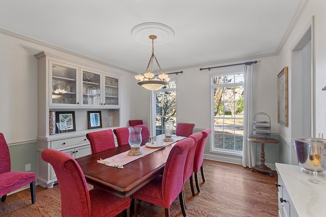 dining space with light hardwood / wood-style flooring and ornamental molding