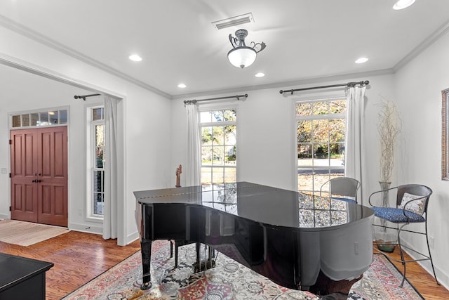 dining area with hardwood / wood-style flooring and crown molding